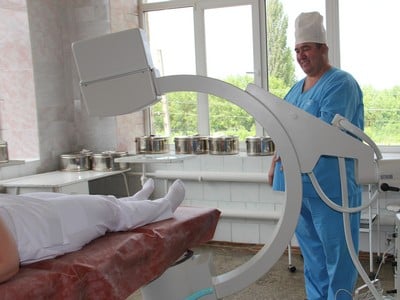 Заведующий травматологическим отделением Александр Хашов обследует пациентку на аппарате «С-дуга»