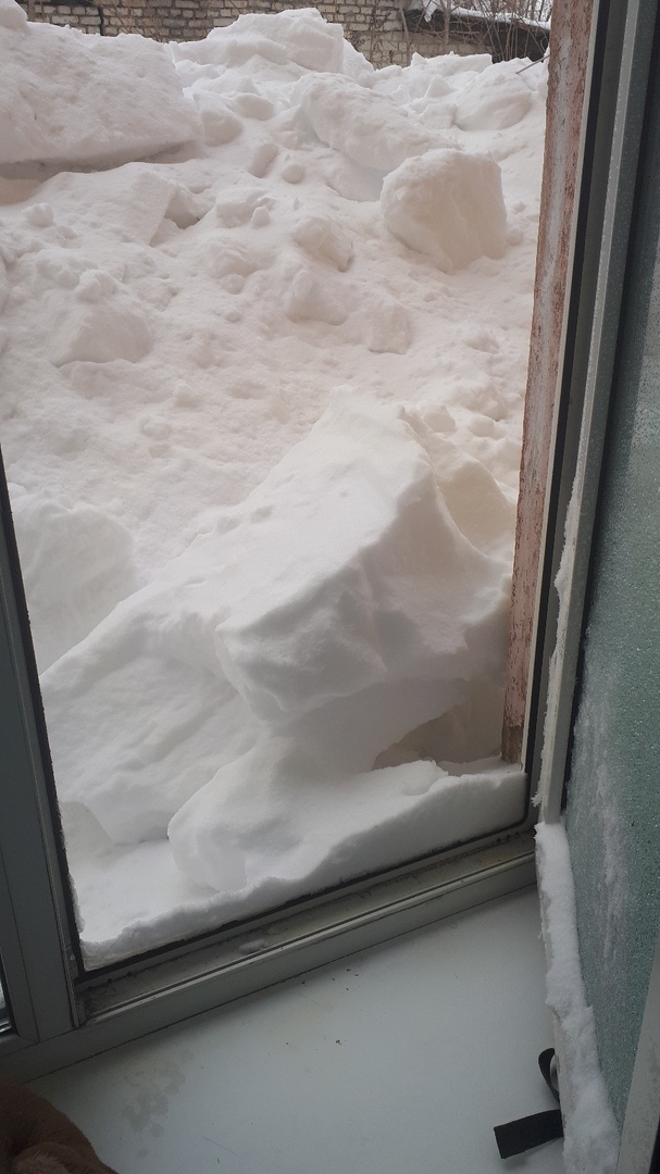 Заваленный снегом с крыши первый этаж дома на Международном проезде.jpg