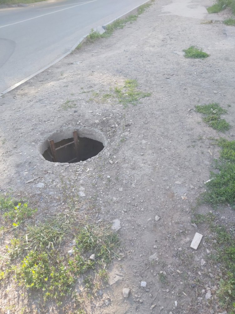 открытый люк на обочине в Заводском