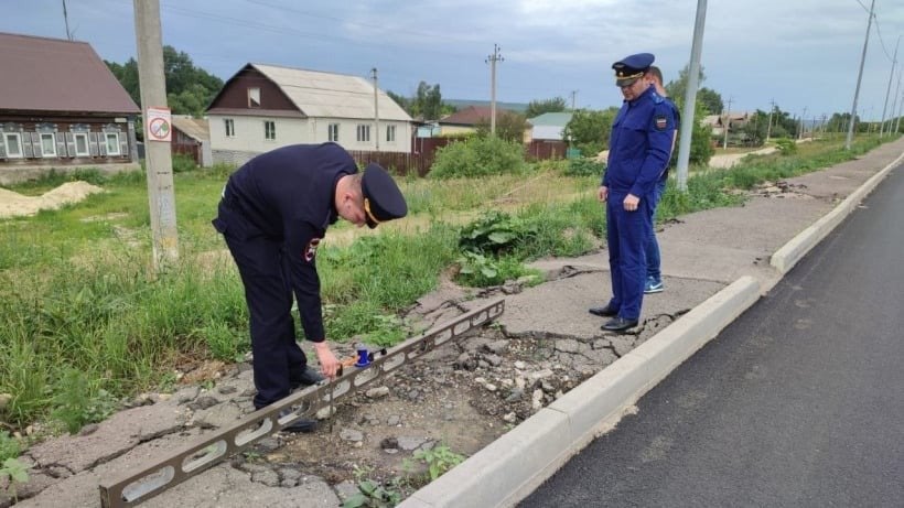 Прокуроры измеряют ямы на тротуаре в Балтае