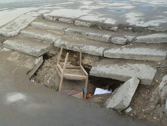 На центральной улице Саратова яму в тротуаре прикрывает деревянный трехногий стул. Фото