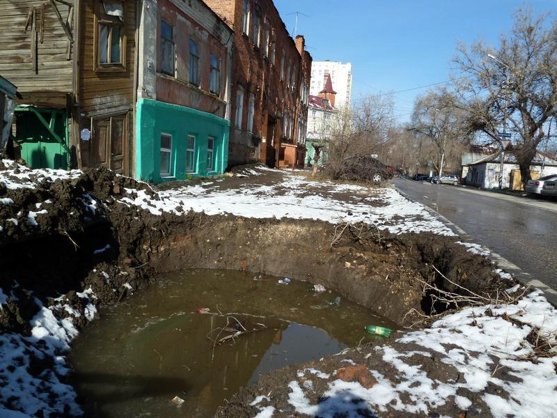 Большая яма на тротуаре в центре Саратова за месяц расширилась и наполнилась водой