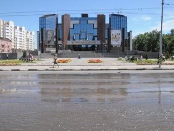 Напротив нового ТЮЗа на проезжую часть и тротуар льется вода 