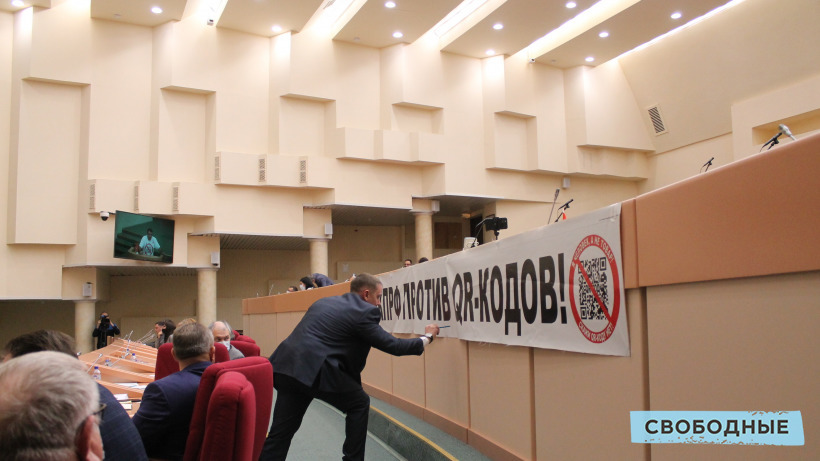 Коммунист Бондаренко вывесил в облдуме плакат против QR-кодов. Депутат-единоросс в ответ начал писать на нем