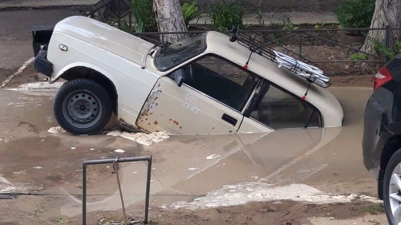 Во дворе саратовской пятиэтажки машина наполовину провалилась в яму с водой